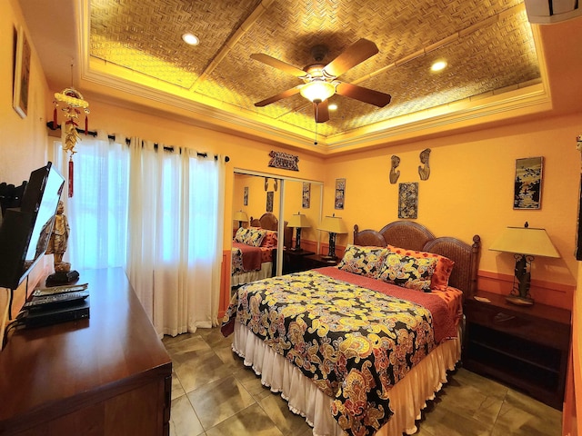 bedroom featuring a raised ceiling, ceiling fan, a closet, and crown molding