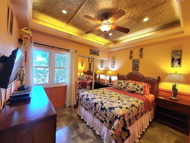 bedroom with ceiling fan, crown molding, and a tray ceiling