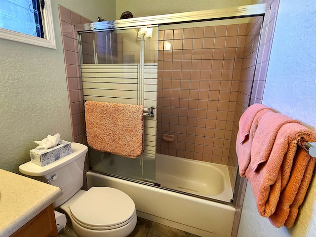 full bathroom with vanity, bath / shower combo with glass door, and toilet