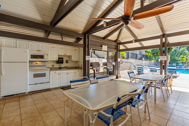 interior space featuring ceiling fan, sink, beamed ceiling, and high vaulted ceiling