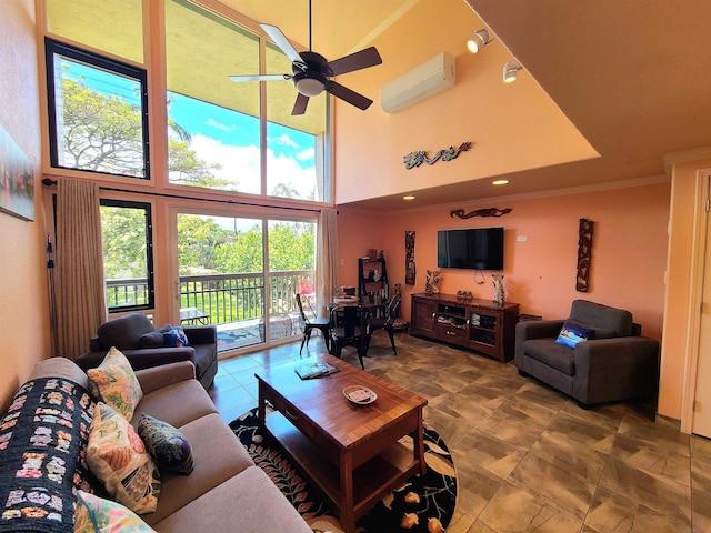 living room with ceiling fan, an AC wall unit, ornamental molding, and a towering ceiling