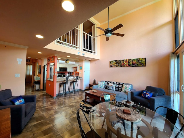 living room with ceiling fan and ornamental molding