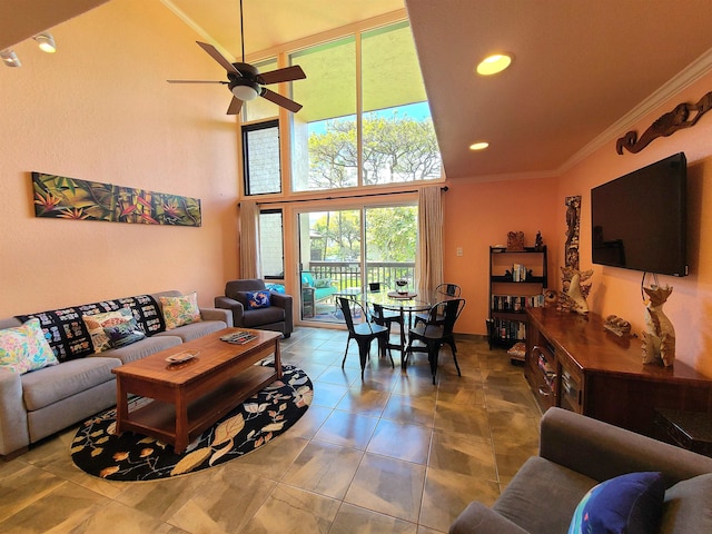 living room featuring tile patterned flooring, ceiling fan, ornamental molding, and a high ceiling