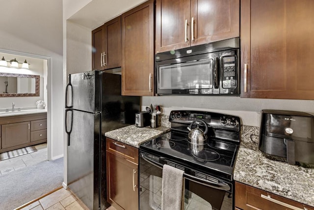 679 S Kihei Rd Unit D205, Kihei, HI 96753 - kitchen featuring a sink, light tile patterned floors, light stone countertops, and black appliances