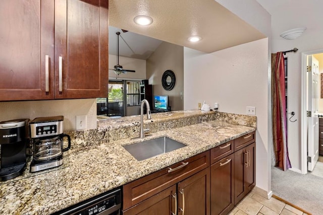 kitchen featuring light stone counters, ceiling fan, sink, kitchen peninsula, and vaulted ceiling