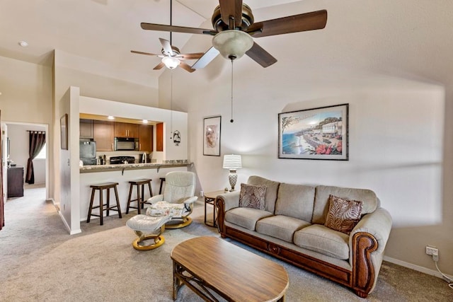 living room featuring light carpet, a towering ceiling, and ceiling fan