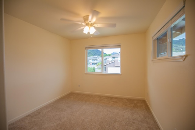 carpeted spare room with ceiling fan