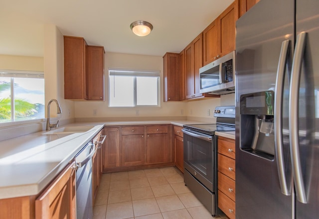 kitchen featuring appliances with stainless steel finishes, light tile patterned floors, and sink