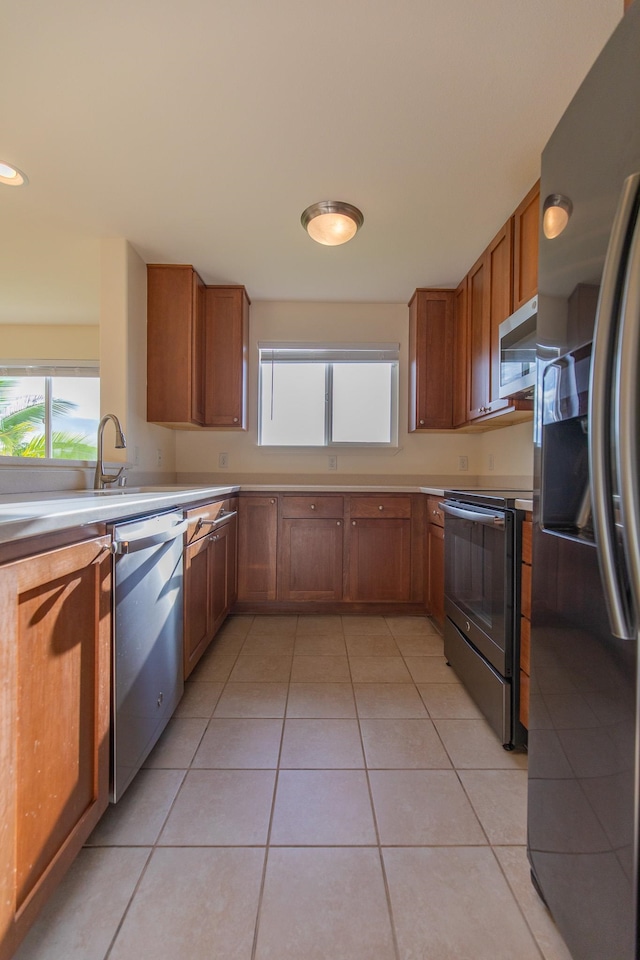 kitchen with appliances with stainless steel finishes and light tile patterned floors