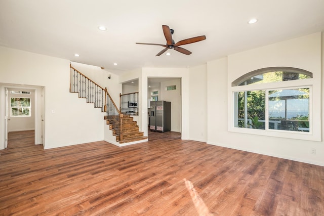 unfurnished living room featuring ceiling fan and hardwood / wood-style floors