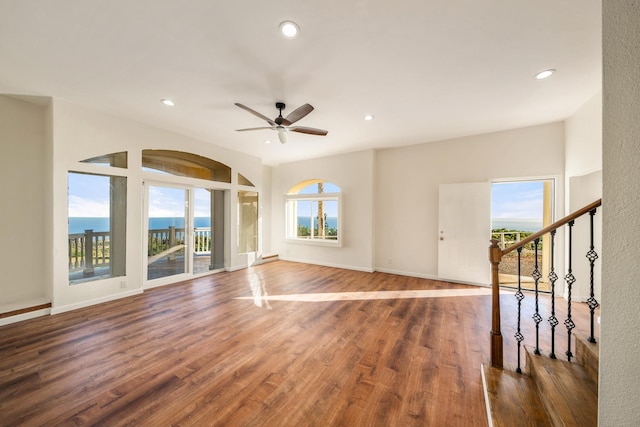 interior space with ceiling fan, dark hardwood / wood-style flooring, and a water view