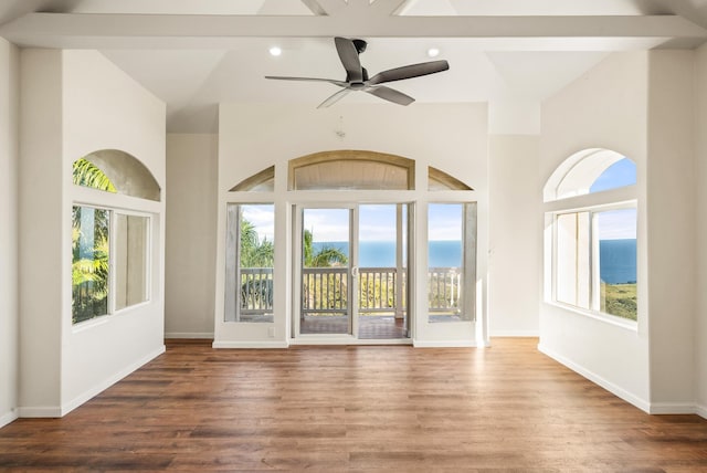 unfurnished living room featuring ceiling fan, a water view, and wood-type flooring