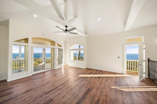 unfurnished room featuring ceiling fan, a water view, a healthy amount of sunlight, and dark hardwood / wood-style floors