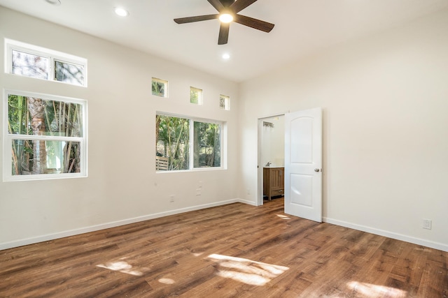 unfurnished bedroom with ceiling fan, dark hardwood / wood-style flooring, and a high ceiling