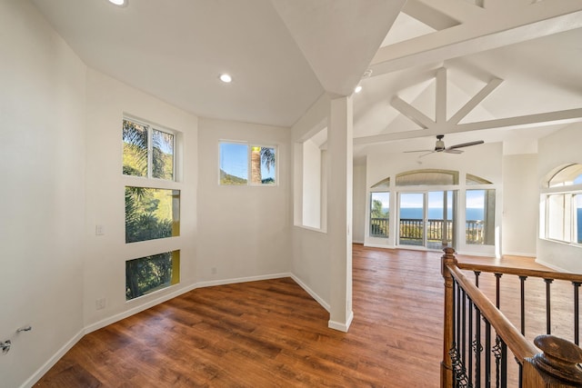 interior space featuring vaulted ceiling with beams, plenty of natural light, dark hardwood / wood-style floors, and ceiling fan