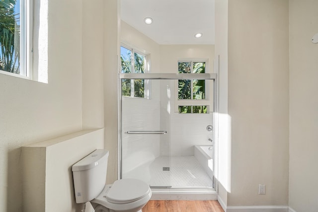 bathroom with hardwood / wood-style floors, toilet, and independent shower and bath