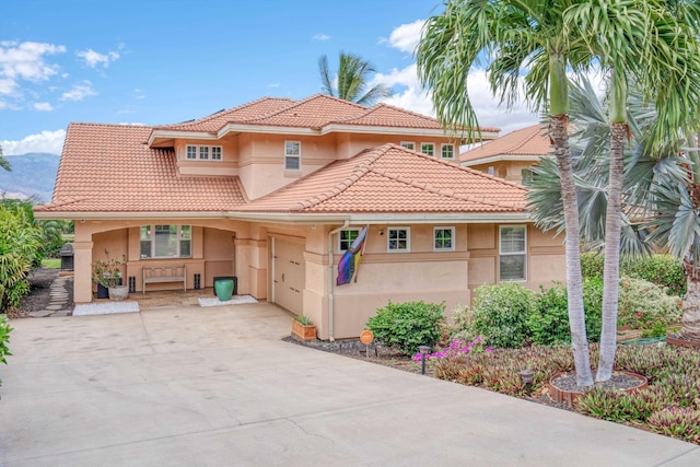 2335 Hihimanu St Unit 117, Kihei, HI 96753 - mediterranean / spanish-style house featuring stucco siding, a tiled roof, driveway, and an attached garage