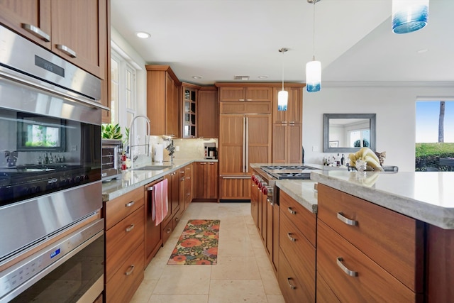 2335 Hihimanu St Unit 117, Kihei, HI 96753 - kitchen with brown cabinetry, light stone countertops, glass insert cabinets, decorative light fixtures, and recessed lighting