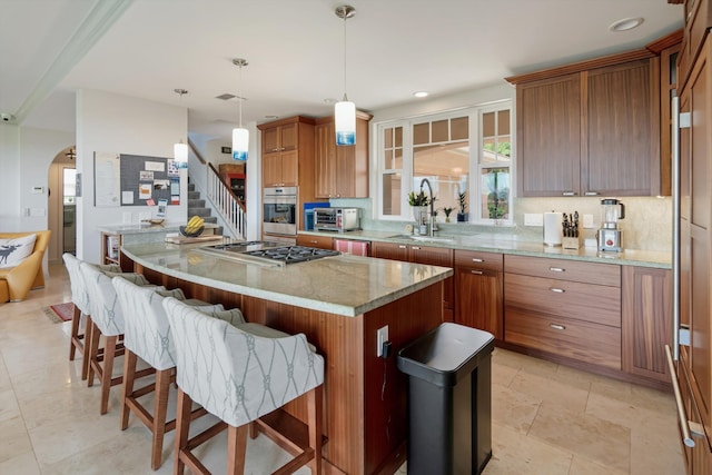 2335 Hihimanu St Unit 117, Kihei, HI 96753 - kitchen with appliances with stainless steel finishes, a kitchen island, brown cabinets, a breakfast bar, and light stone counters