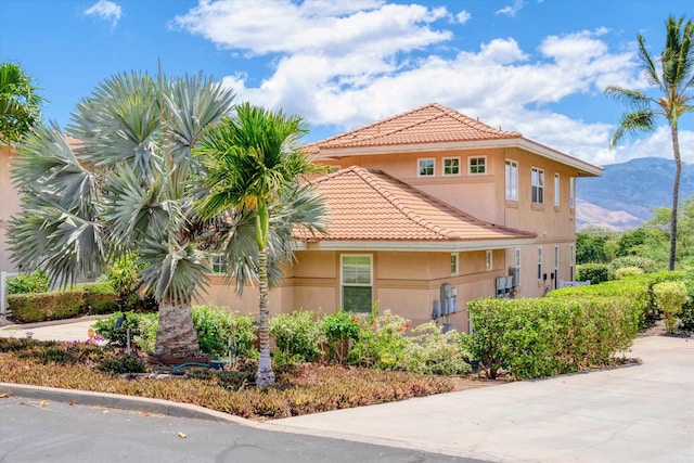 2335 Hihimanu St Unit 117, Kihei, HI 96753 - view of side of home featuring a tile roof, stucco siding, and a mountain view