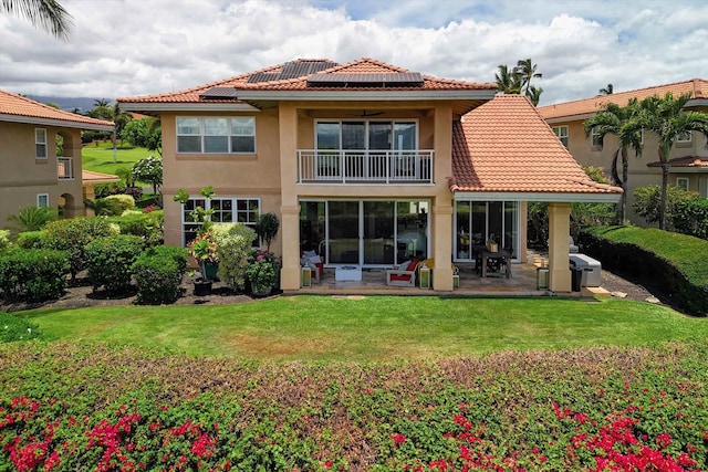 2335 Hihimanu St Unit 117, Kihei, HI 96753 - back of house with a balcony, roof mounted solar panels, a patio, and a lawn