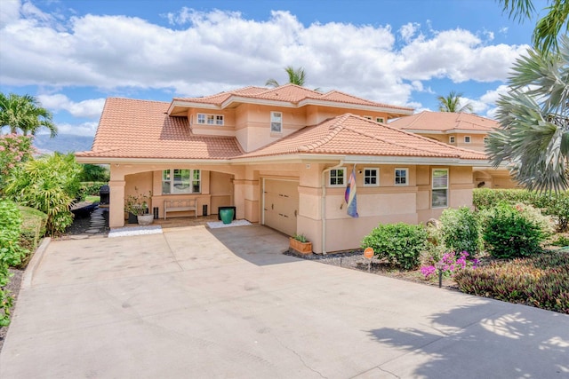 2335 Hihimanu St Unit 117, Kihei, HI 96753 - mediterranean / spanish-style house featuring stucco siding, a tile roof, an attached garage, and concrete driveway