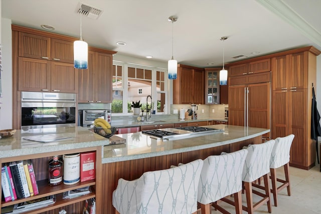 2335 Hihimanu St Unit 117, Kihei, HI 96753 - kitchen with appliances with stainless steel finishes, brown cabinetry, a kitchen bar, and recessed lighting