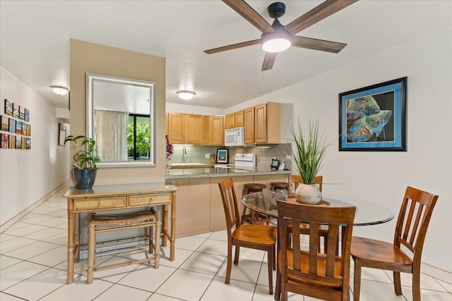 dining room featuring ceiling fan, sink, and light tile floors