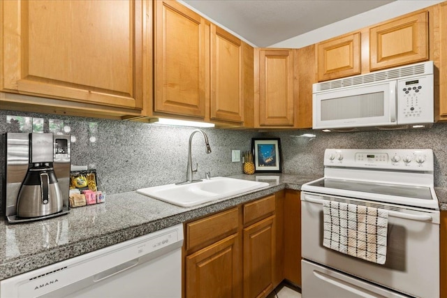 kitchen with white appliances, sink, and backsplash