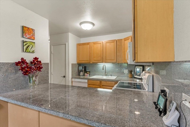 kitchen featuring kitchen peninsula, dishwasher, stove, backsplash, and sink