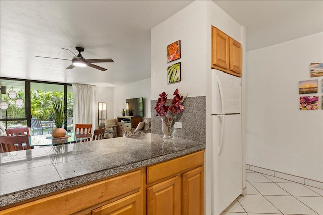 kitchen with white fridge, light tile flooring, and ceiling fan