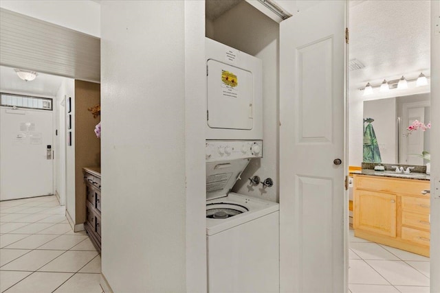 laundry room with stacked washing maching and dryer and light tile floors