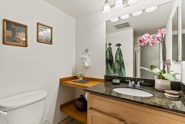 bathroom with vanity with extensive cabinet space and toilet