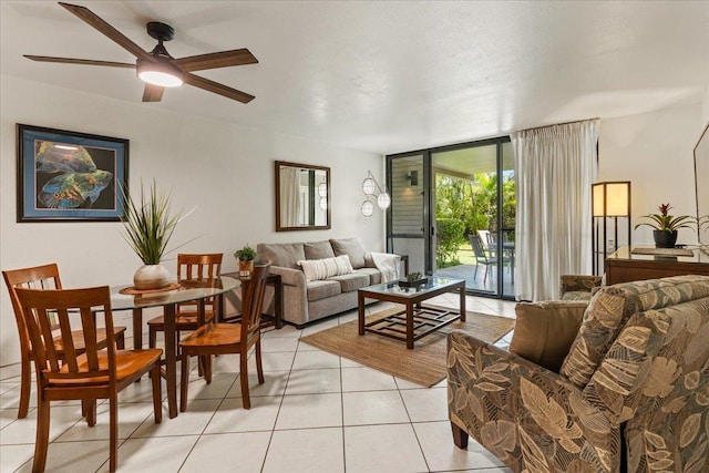 living room featuring ceiling fan, expansive windows, and light tile floors