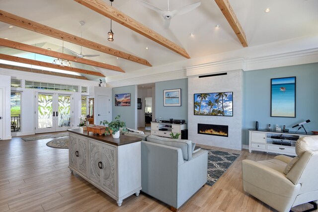 living room featuring french doors, beamed ceiling, ceiling fan, a fireplace, and light hardwood / wood-style floors