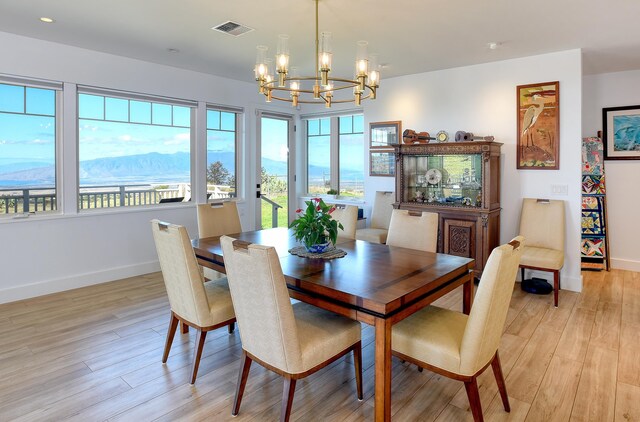 dining area with an inviting chandelier and light hardwood / wood-style flooring