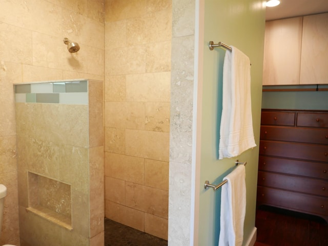 bathroom featuring toilet and a tile shower