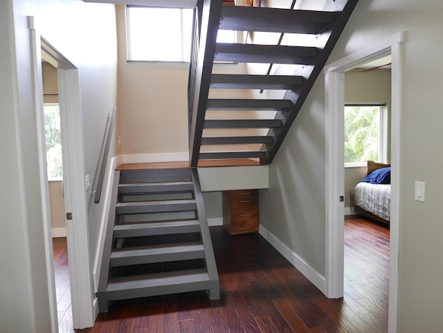 stairway with hardwood / wood-style floors and built in desk