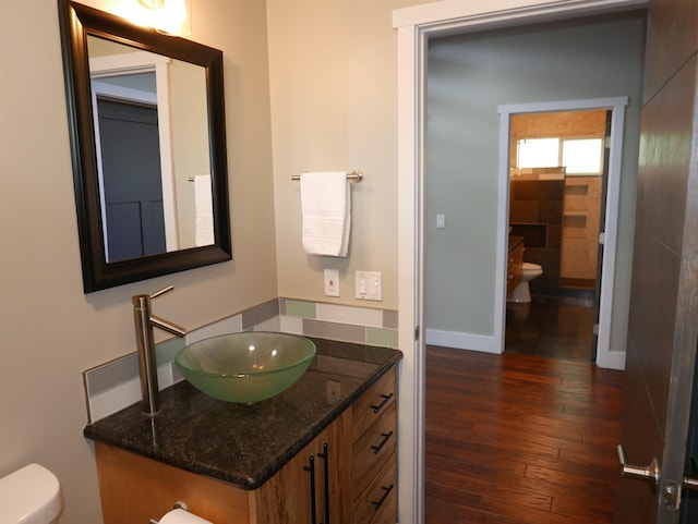 bathroom with hardwood / wood-style flooring, vanity, and toilet