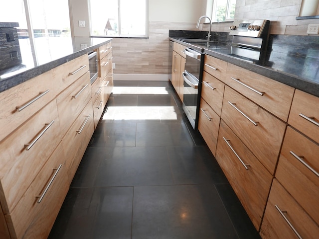 kitchen featuring sink, electric range, dark tile patterned floors, light brown cabinetry, and wall oven