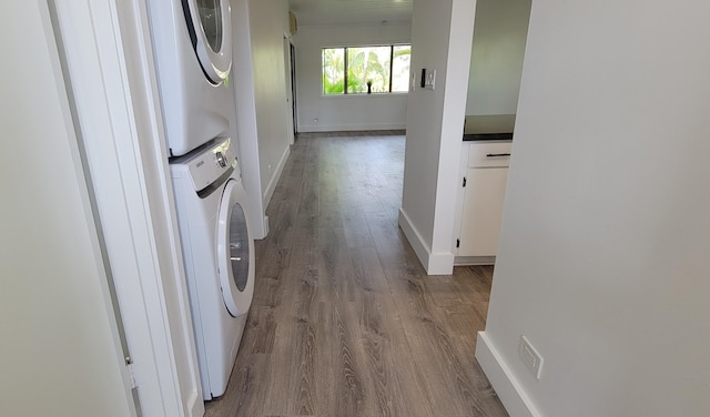 laundry room featuring light hardwood / wood-style floors and stacked washer / drying machine