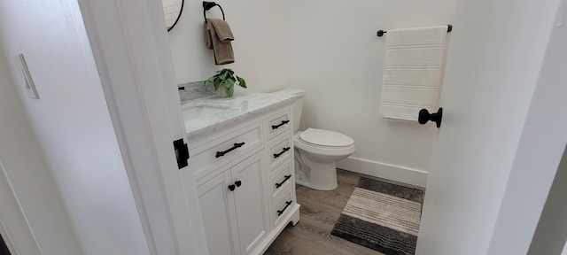 bathroom featuring hardwood / wood-style flooring, vanity, and toilet