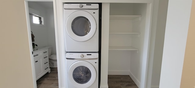 laundry room featuring dark hardwood / wood-style flooring and stacked washer / dryer