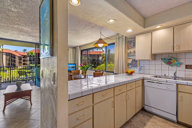 kitchen featuring tasteful backsplash, tile counters, dishwasher, and light brown cabinets