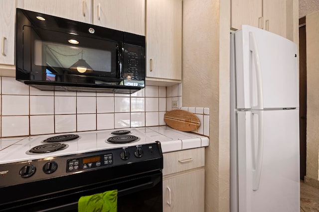 kitchen featuring decorative backsplash, light brown cabinetry, and black appliances