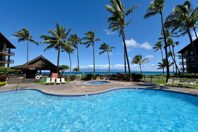 view of pool with a water view, a community hot tub, and a gazebo