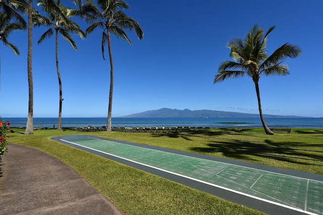 view of property's community with a water and mountain view and a lawn