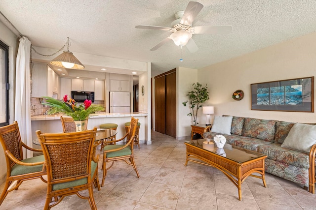 tiled living room featuring ceiling fan and a textured ceiling