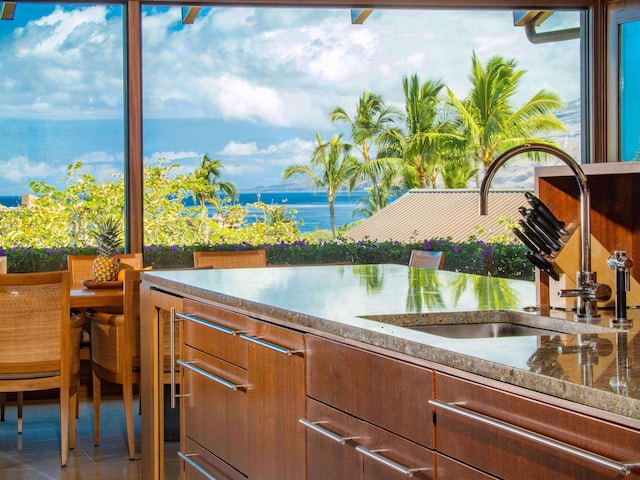 3100 Wailea Alanui Dr Unit 12, Kihei, HI 96753 - interior space featuring a sink, a water view, and brown cabinetry