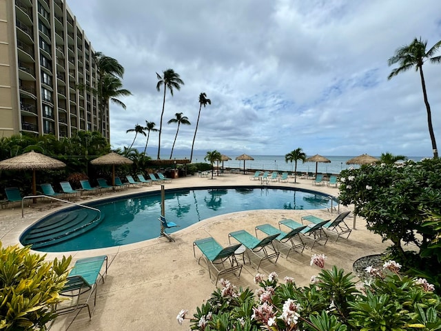 view of swimming pool with a patio and a water view